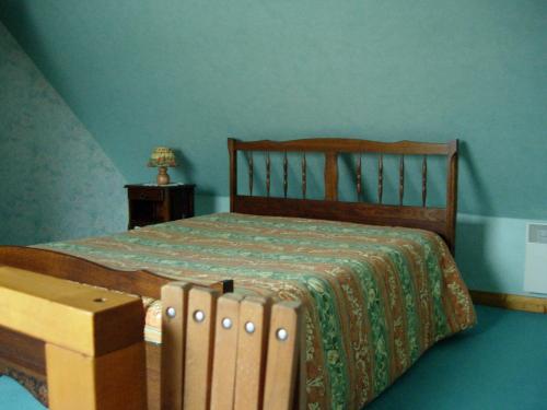 une chambre avec un lit et une table avec une lampe dans l'établissement Petite maison près de la mer à Saint-Cast-le-Guildo, à Saint-Cast-le-Guildo