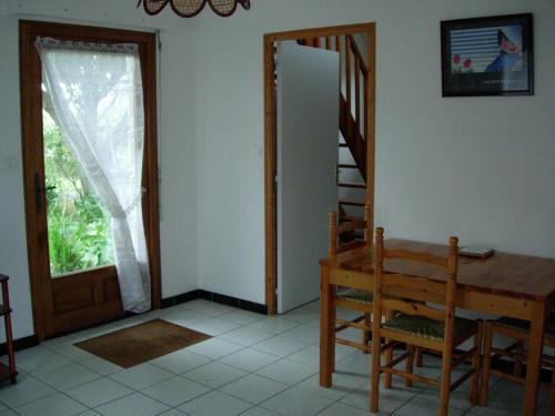 une salle à manger avec une table en bois et une porte dans l'établissement Petite maison près de la mer à Saint-Cast-le-Guildo, à Saint-Cast-le-Guildo