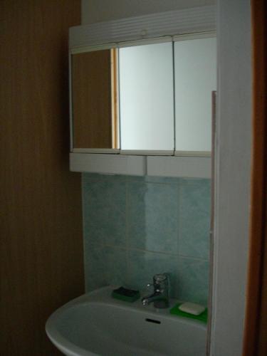 une salle de bain avec un lavabo et un meuble blanc dans l'établissement Petite maison près de la mer à Saint-Cast-le-Guildo, à Saint-Cast-le-Guildo