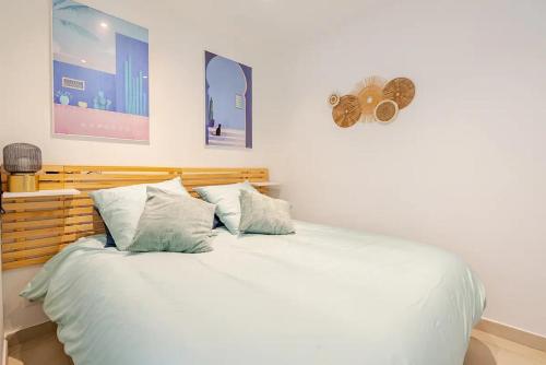 une chambre avec un lit avec des draps blancs et des oreillers dans l'établissement Magnifique 2 pièces avec balcon proche Martinez et Croisette, à Cannes