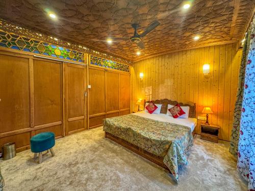 a bedroom with a bed in a room with wooden walls at Peacock Houseboats in Srinagar