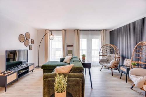 a living room with a couch and a tv at Condo 201 - District Branché St-Roch Parking inclus in Quebec City