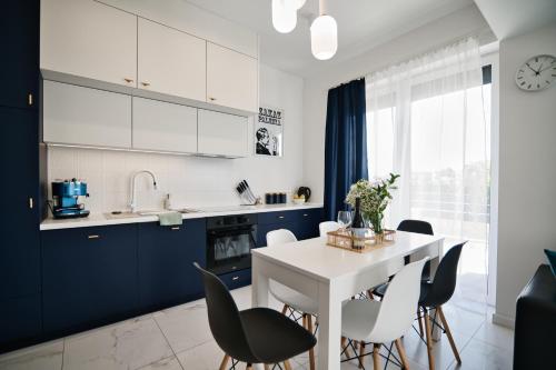 a kitchen with blue cabinets and a white table and chairs at Pankrac 2 by Housine in Zator