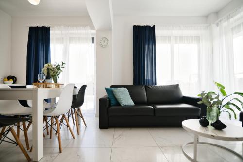a living room with a black couch and a table at Pankrac 2 by Housine in Zator