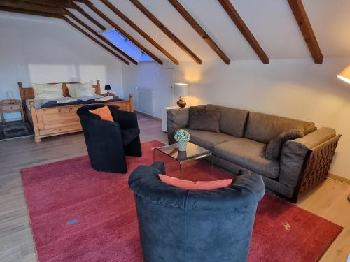 a living room with a couch and chairs and a bed at BellaRosa in Emmetten