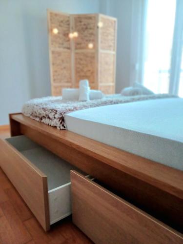 a bedroom with a large bed with wooden drawers at Angela's Apartment in Chalkida