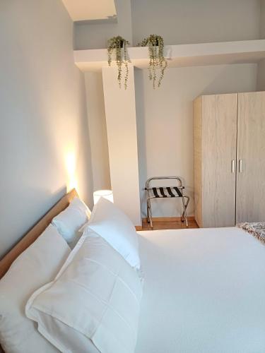 a bedroom with a bed with white sheets and pillows at Angela's Apartment in Chalkida