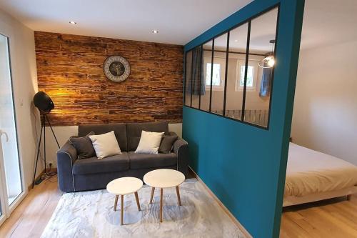 un salon avec un canapé et deux tables dans l'établissement Meublé de tourisme 3 étoiles avec terrasse et jardin, à Bagnols-sur-Cèze