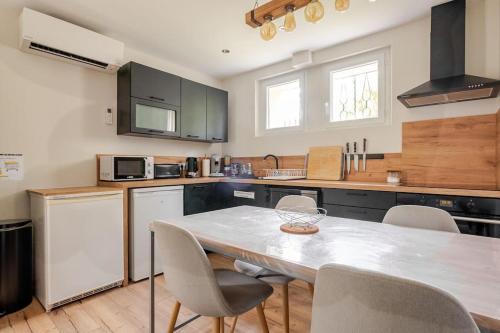 une cuisine avec une table et des chaises dans l'établissement Meublé de tourisme 3 étoiles avec terrasse et jardin, à Bagnols-sur-Cèze