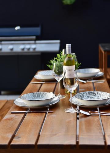 a wooden table with plates and wine glasses on it at Apartmány Čerňák - Dolňák - 4-6 osob, terasa, dvě parkovací místa in Černý Dŭl