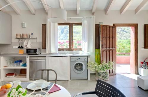 a kitchen with a washing machine and a table at La Joya del Valle de Ricote in Villanueva de Río Segura