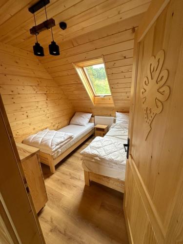 a room with two beds in a wooden cabin at Dom Na Brzegu in Limanowa
