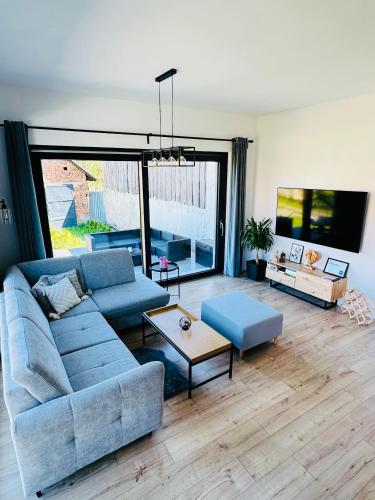 a living room with a blue couch and a table at Apartmány 400 in Veľká Lomnica