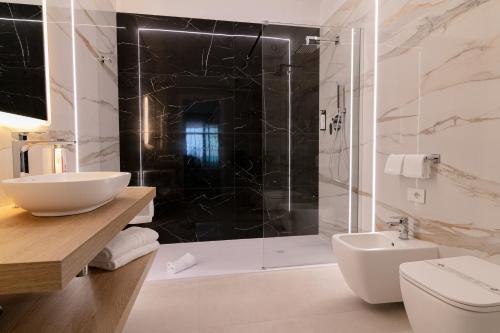 a bathroom with a shower and a toilet and a sink at King's Rooms in Termoli