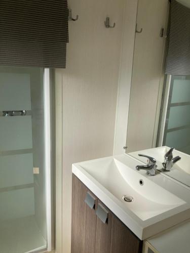 une salle de bain avec un lavabo blanc et un miroir dans l'établissement camping paisible Marvilla park, à Agde