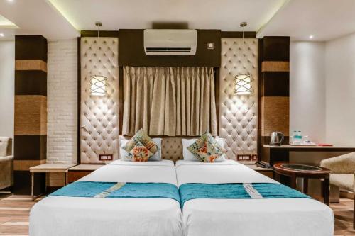 a bedroom with a large white bed in a room at Hotel ACME in Kolkata