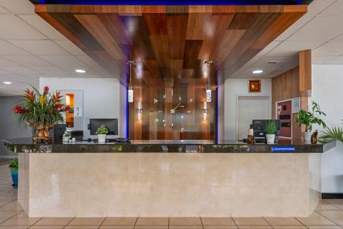 an office lobby with a reception counter with plants at Rodeway Inn Clermont - Minneola - Groveland - Leeseburg in Clermont