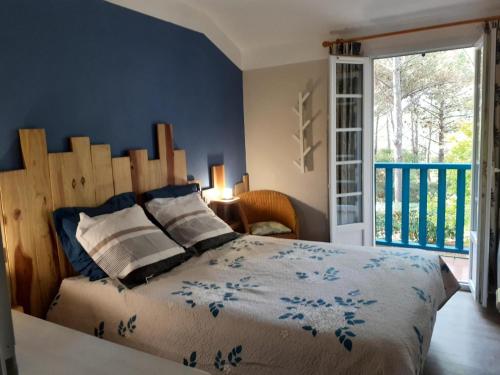 une chambre avec un lit avec une tête de lit en bois dans l'établissement Les maisons de Moliets - maeva Home - Maison 3 Pièces 6 Personnes - Sélection MAE-5144, à Moliets-et-Maa