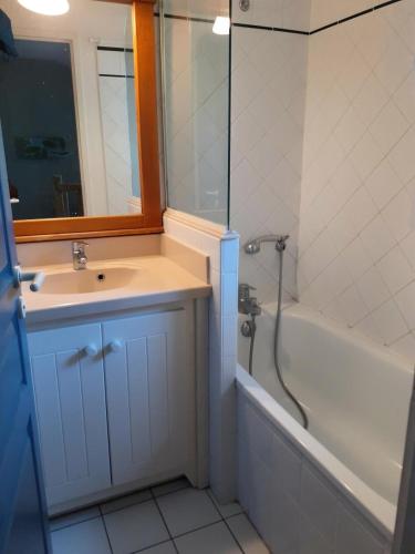 une salle de bain avec un lavabo, une baignoire et un miroir dans l'établissement Les maisons de Moliets - maeva Home - Maison 3 Pièces 6 Personnes - Sélection MAE-5144, à Moliets-et-Maa