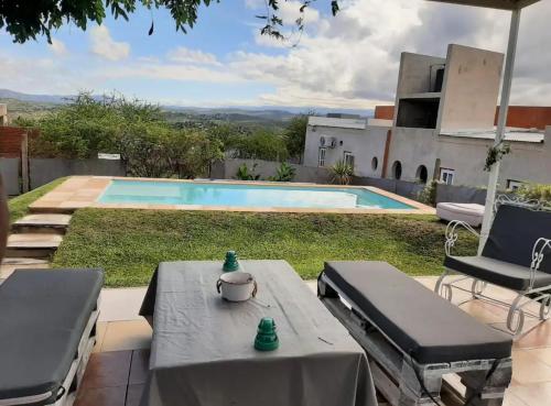 a patio with a table and chairs and a swimming pool at Mauro y Sonia in Estancia Vieja