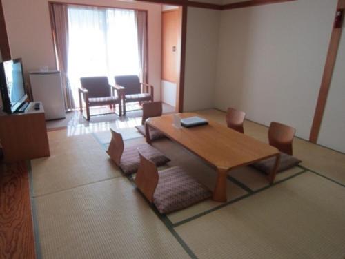 a living room with a wooden table and chairs at Hotel Tetora Resort SendaiIwanuma - Vacation STAY 00296v in Natori