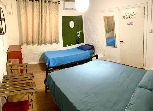 a room with two beds and a bench in it at Dotan's Boutique Guesthouse - By The Beach! in Tel Aviv