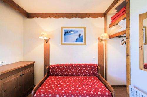 une chambre avec un lit rouge dans une pièce dans l'établissement Résidence La Crête du Berger - maeva Home - Studio 4 personnes - Confort MAE-1764, à Agnières-en-Dévoluy