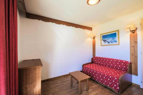 un salon avec un canapé rouge et une table dans l'établissement Résidence La Crête du Berger - maeva Home - Appartement 2 pièces 4 personnes - Confort MAE-1774, à Agnières-en-Dévoluy