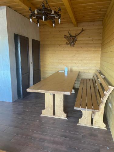 a wooden table and a bench in a room at New Continent in Bushtyno
