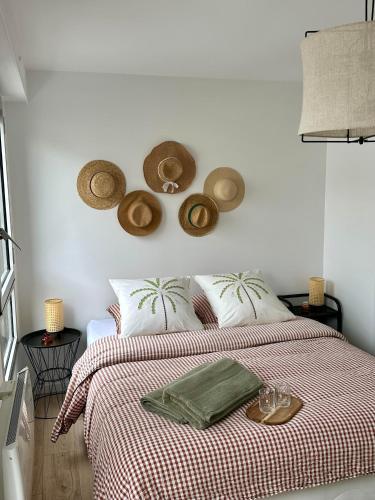 - une chambre avec un lit avec des chapeaux sur le mur dans l'établissement Confortable appartement avec terrasses entre Paris et Disney, à Ozoir-la-Ferrière