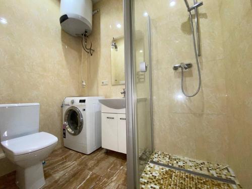 a bathroom with a toilet a sink and a washing machine at Apartment on Dragomirova in Kyiv