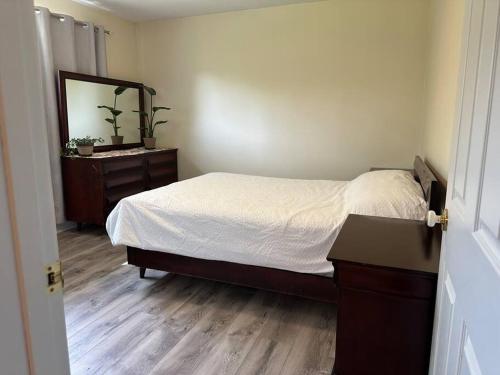 a bedroom with a bed and a dresser and a mirror at Your Search Stops Here, Homey Three Bedroom in Copper Cliff