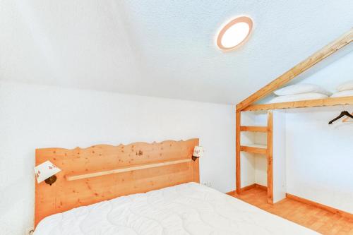 une chambre avec un lit avec une tête de lit en bois dans l'établissement Résidence La Crête du Berger - maeva Home - Appartement 2 pièces 6 personnes - Budget MAE-2764, à Agnières-en-Dévoluy