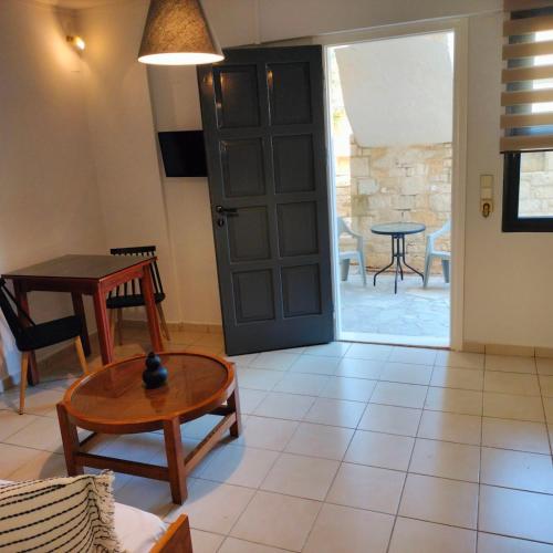 a living room with a table and a door at Nancy - Chara Apartments in Karteros