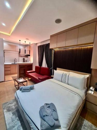 a bedroom with a large white bed and a red couch at Luxury self-contained Studio Apt at Ikoyi, Lagos in Lagos