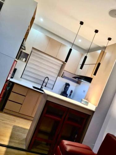 a kitchen with white cabinets and a red couch at Luxury self-contained Studio Apt at Ikoyi, Lagos in Lagos
