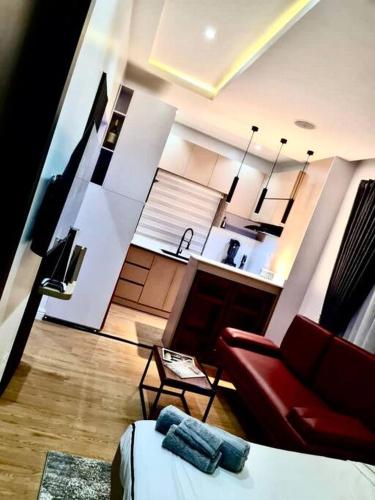 a living room with a red couch and a kitchen at Luxury self-contained Studio Apt at Ikoyi, Lagos in Lagos