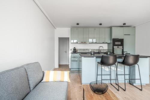 un salon avec un canapé et une cuisine dans l'établissement Le Versailles Soleil Classé 3 étoiles Charme & vue Chapelle Royale, à Versailles