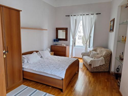 a bedroom with a bed and a chair and a window at Dolce Vita Old Town Studio in Dubrovnik