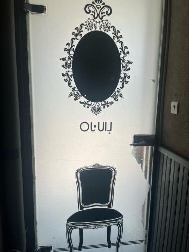 a chair sitting in front of a wall with a mirror at Les Bêtises, Duplex Hyper-centre in Cambrai