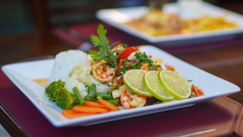 a plate of food with shrimp and vegetables on a table at SJ Tour - San Juan Foz do Iguaçu in Foz do Iguaçu