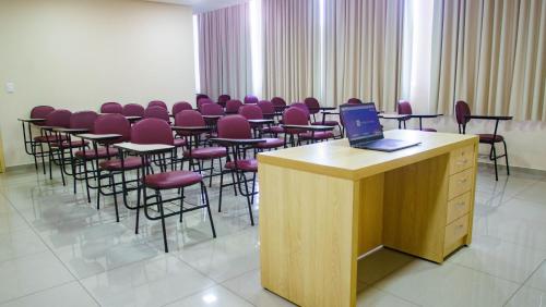 a conference room with chairs and a desk with a laptop at SJ Tour - San Juan Foz do Iguaçu in Foz do Iguaçu