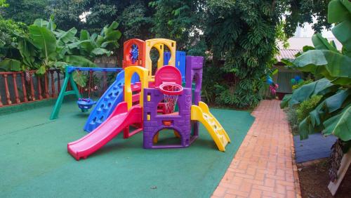 a group of childrens playground equipment on a green ground at SJ Tour - San Juan Foz do Iguaçu in Foz do Iguaçu