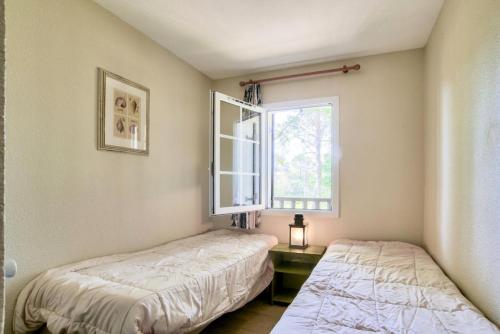 deux lits dans une chambre avec une fenêtre dans l'établissement Les maisons de Moliets - maeva Home - Maison 4 pièces 8 personnes - Confort MAE-2094, à Moliets-et-Maa