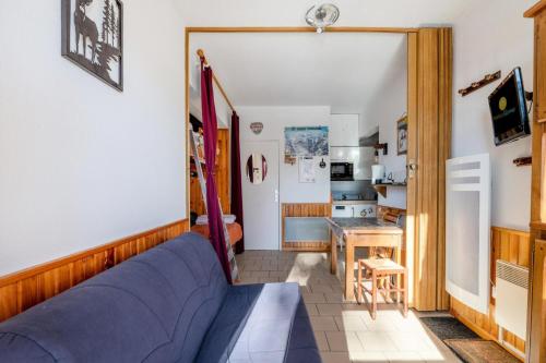 un salon avec un canapé bleu et une cuisine dans l'établissement Résidence Val Cristal - maeva Home - Studio 5 Personnes - Budget MAE-2444, à Font-Romeu-Odeillo-Via