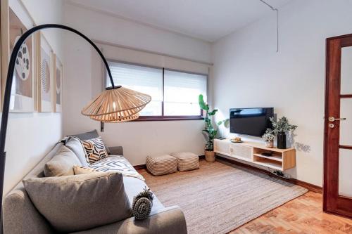 a living room with a couch and a television at Apartamento com terraço in Porto