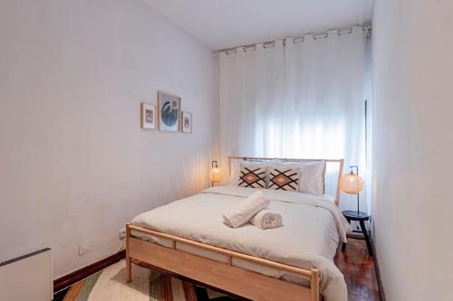 a bedroom with a large bed with white walls at Apartamento com terraço in Porto