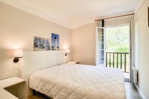 une chambre avec un lit et une grande fenêtre dans l'établissement Les maisons de Moliets - maeva Home - Maison 3 pièces 6 personnes - Prestige MAE-2154, à Moliets-et-Maa