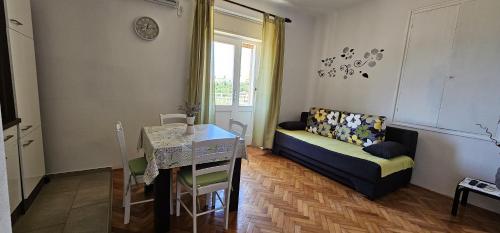 a living room with a couch and a table at APARTMANI SANDRA PRPIĆ in Rab