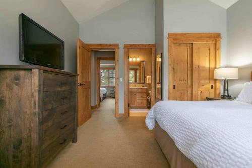 a bedroom with a bed and a flat screen tv at Fairway Drive 13113 by East West Hospitality in Truckee